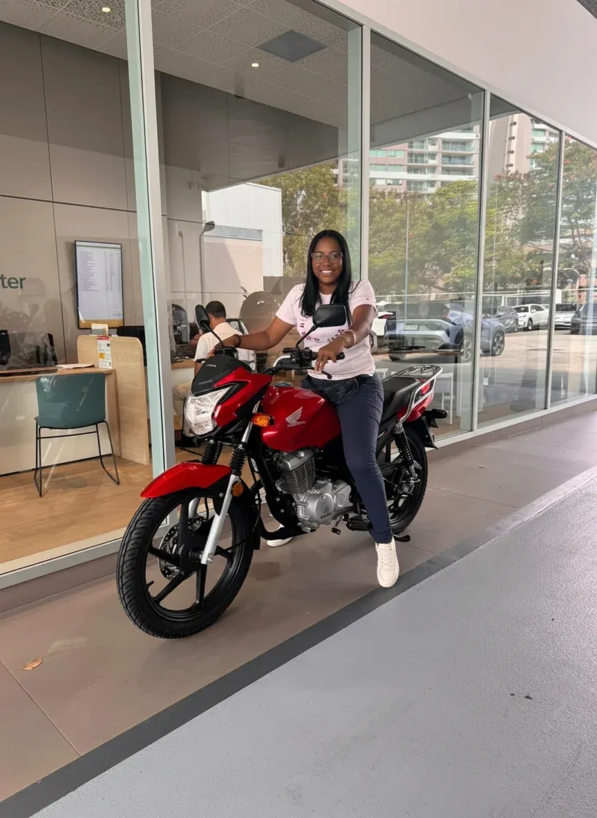 Entrega de motocicleta Honda roja financiada por Gaital a María González en Panamá