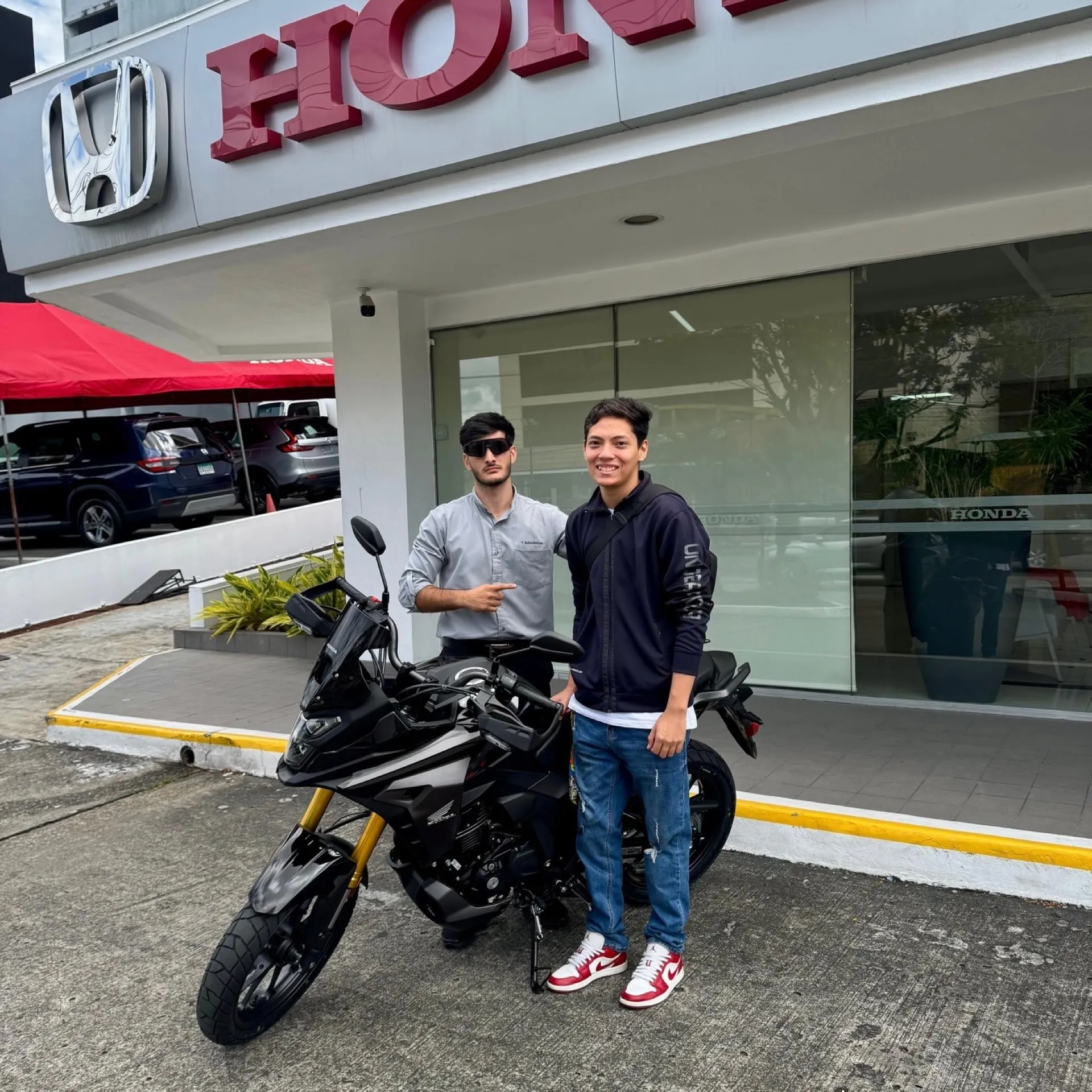 Amigos celebrando entrega de moto en concesionaria Honda Panamá